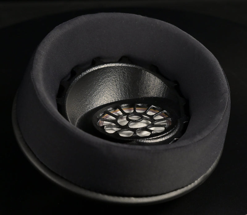ETA ULI earcup shown at an angle, black suede earpad surrounding the 3D-printed driver baffle with floral spoke pattern over the AlNiCo magnet