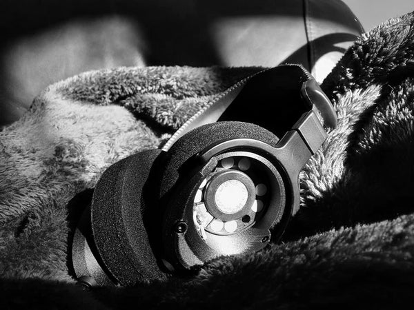 2021 — Mini Open — ETA Mini Open headphone resting on fleece blanket showing vented open-back driver chassis, black and white