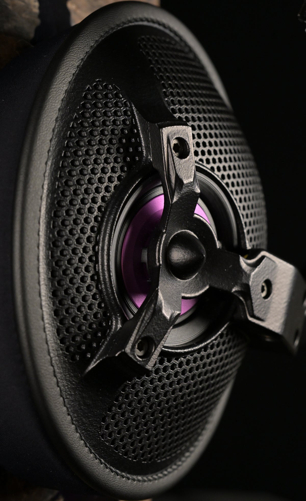 Macro close-up of the ETA ULI open-back driver showing the perforated grille, three-spoke chassis and purple AlNiCo voice coil