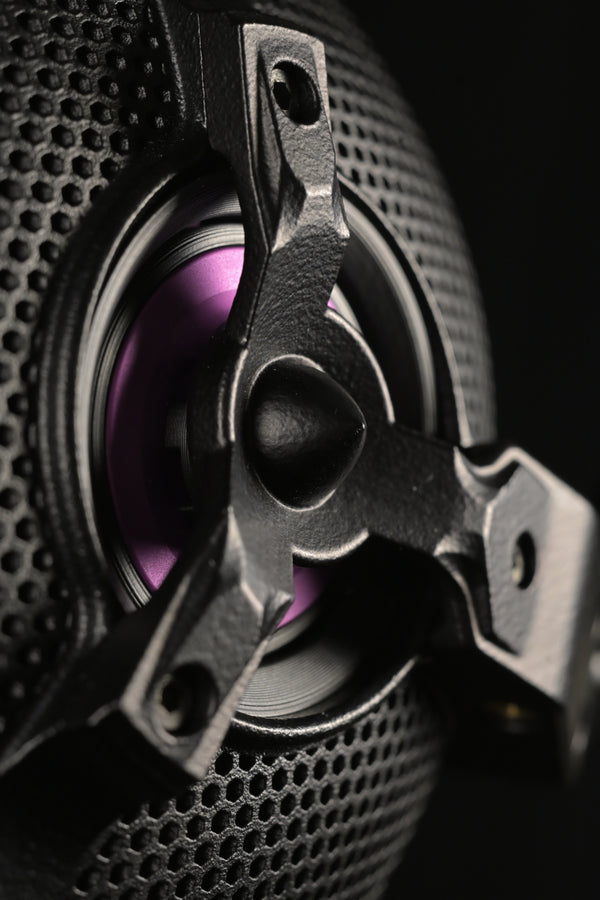 2025 — ETA ULI (Preorder) — AlNiCo Headphone — Macro close-up of the ETA ULI open-back driver showing the perforated black grille, three-spoke chassis bracket and purple AlNiCo voice coil