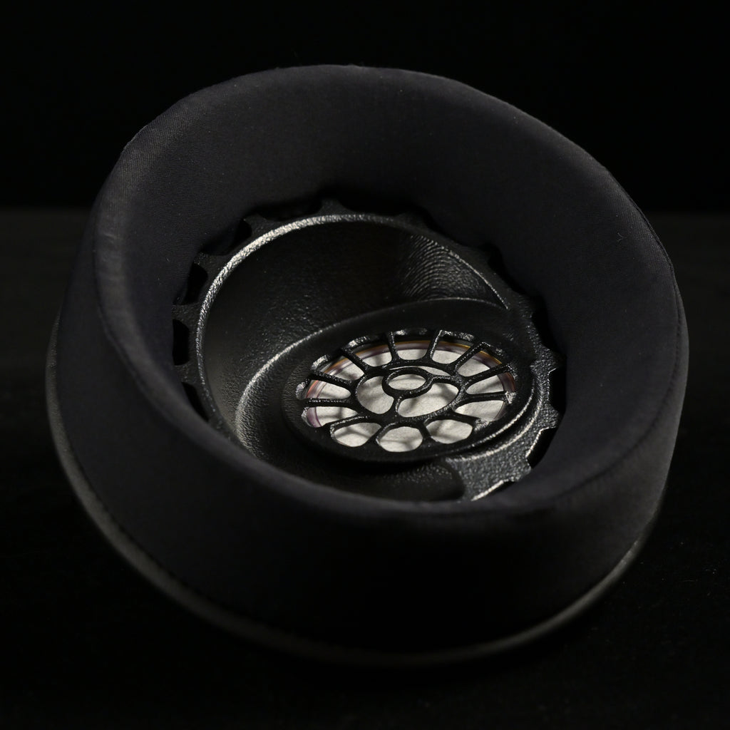 ETA ULI earcup viewed from above, black suede earpad surrounding the 3D-printed driver baffle with floral spoke pattern over the AlNiCo magnet