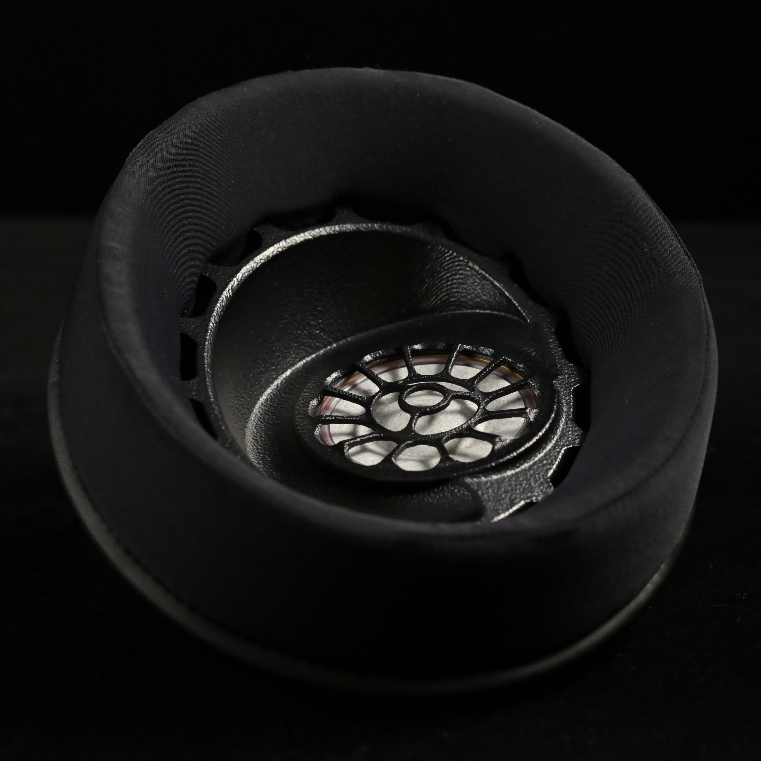 ETA ULI earcup viewed from above, black suede earpad surrounding the 3D-printed driver baffle with floral spoke pattern over the AlNiCo magnet