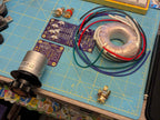 HID headphone preamp prototype with toroidal transformer and PCB layout on workbench